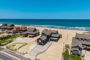 A beachfront hotel with multiple buildings, a sandy beach, and the ocean in the background.