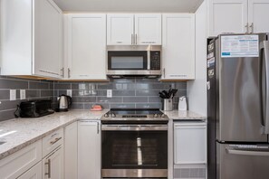 A modern kitchen with stainless steel appliances, including a microwave, oven, and refrigerator.