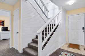 A staircase with white railings and carpeted steps leading to a landing. - Bay Meadow 20: Soundfront, spectacular sunsets, dog-friendly, elevator, community pool (Nags Head)