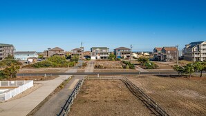 Zona residencial con casas, cielo despejado y una calle pavimentada.