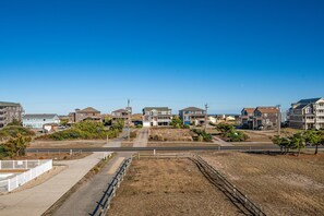 A residential area with houses, a clear sky, and a paved road.