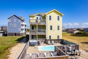 A two-story building with a pool and outdoor seating.