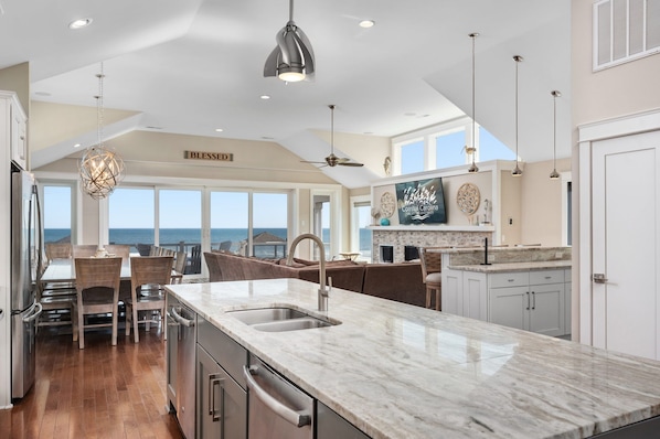 A spacious kitchen with a large island, modern appliances, and a view of the ocean.