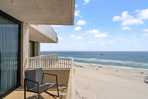 Een balkon met uitzicht op het strand en de oceaan.