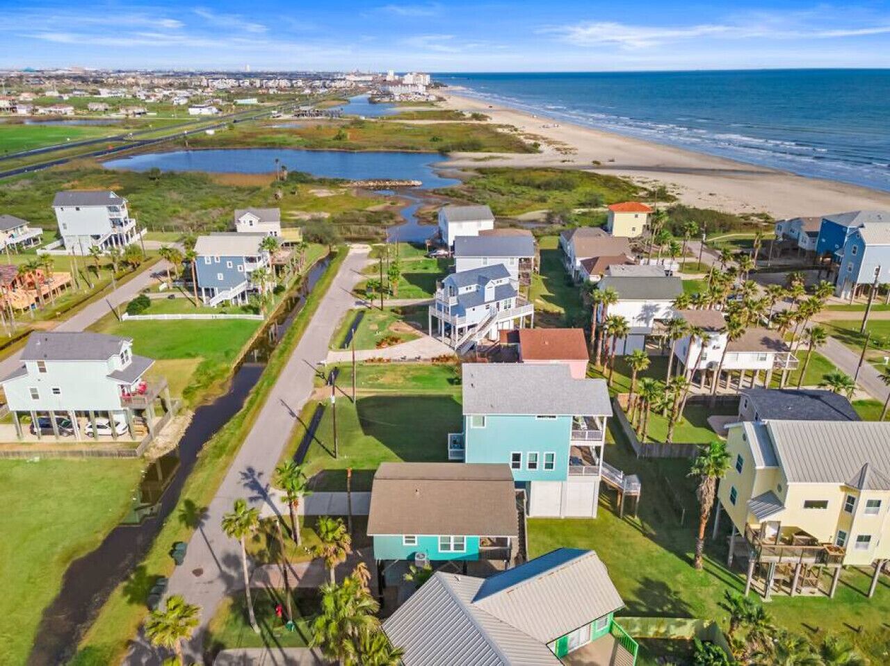 A coastal residential area with houses, a beach, and a water body.