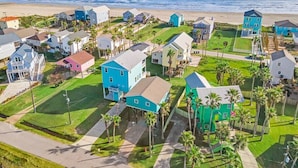 Zona residencial costera con casas, una playa y cielo despejado.