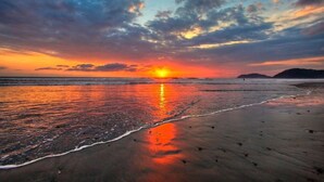 A beach at sunset with a calm sea and a clear sky. - Newly Renovated Condo One Block From Beach (Buenos Aires)
