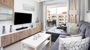 En moderne stue med et fladskærms-tv, et træskab og en sofa.