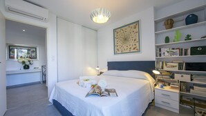 A neatly arranged bedroom with a large bed, bedside tables, a bookshelf, and a desk with a chair. - Appartement Liberation 2, Nice, France (Nice)
