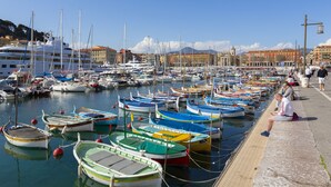 A marina with numerous boats docked, a waterfront promenade, and buildings in the background. - Appartement Liberation 2, Nice, France (Nice)