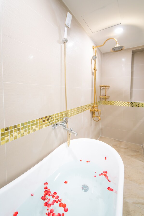 Un baño con bañera, ducha y pared de azulejos con diseño de cuadros.