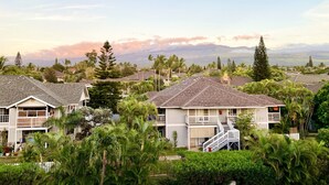 A residential area with houses featuring two-story structures, balconies, and lush greenery. - Maui South Kihei New Modern Spacious Ocean View Condo, 5 mins walk to beach! (KIHEI)
