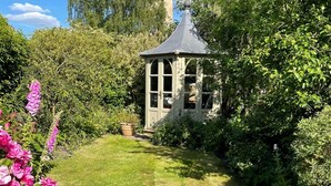 Un jardin agrémenté d’un kiosque, d’une pelouse et de diverses plantes.