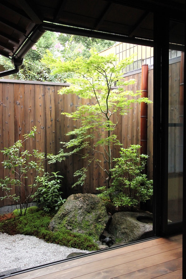A wooden deck with a view of a wooden fence and trees.