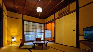 Una habitació tradicional japonesa amb tatami, una taula baixa i portes corredisses.