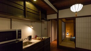 Una cuina tradicional japonesa amb microones, rentapelats i armaris de fusta.