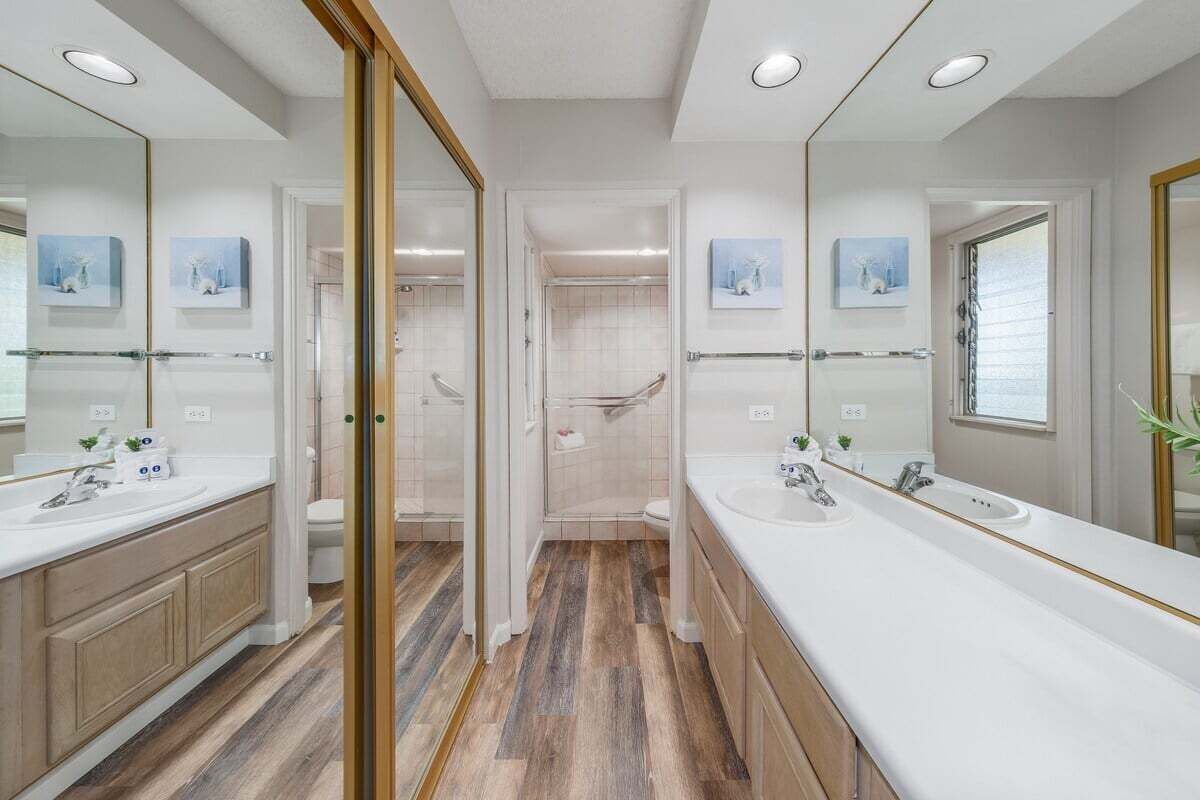 A modern bathroom with two sinks, a walk-in shower, and a glass door leading to the shower.