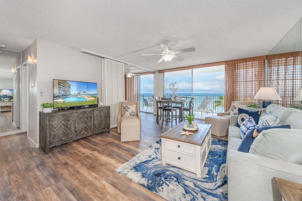 Een ruime woonkamer met een grote televisie, een eethoek en een balkon met uitzicht.