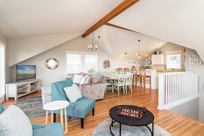 Ein geräumiges Loft mit hohen Decken, einer Essecke mit Küche und einem Wohnzimmer mit Fernseher und Sitzgelegenheiten.