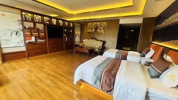 A hotel room with a large bed, a seating area, and a TV.