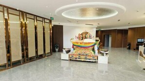 A spacious lobby with a central decorative altar, a reception desk, and a modern ceiling design. - Naqu Zangdi Tianxiang Hotel (Nagqu)