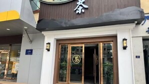 A hotel entrance with a prominent sign, a glass door, and a small outdoor seating area visible through the entrance. - Naqu Zangdi Tianxiang Hotel (Nagqu)