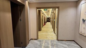 A hotel hallway with a marble floor, wooden doors, and a corridor leading to a room. - Naqu Zangdi Tianxiang Hotel (Nagqu)