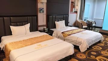 A hotel room with two beds, a large window, and a seating area.