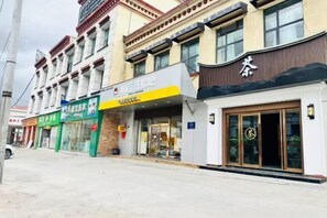 A multi-story building with various shops on the ground floor. - Naqu Zangdi Tianxiang Hotel (Nagqu)