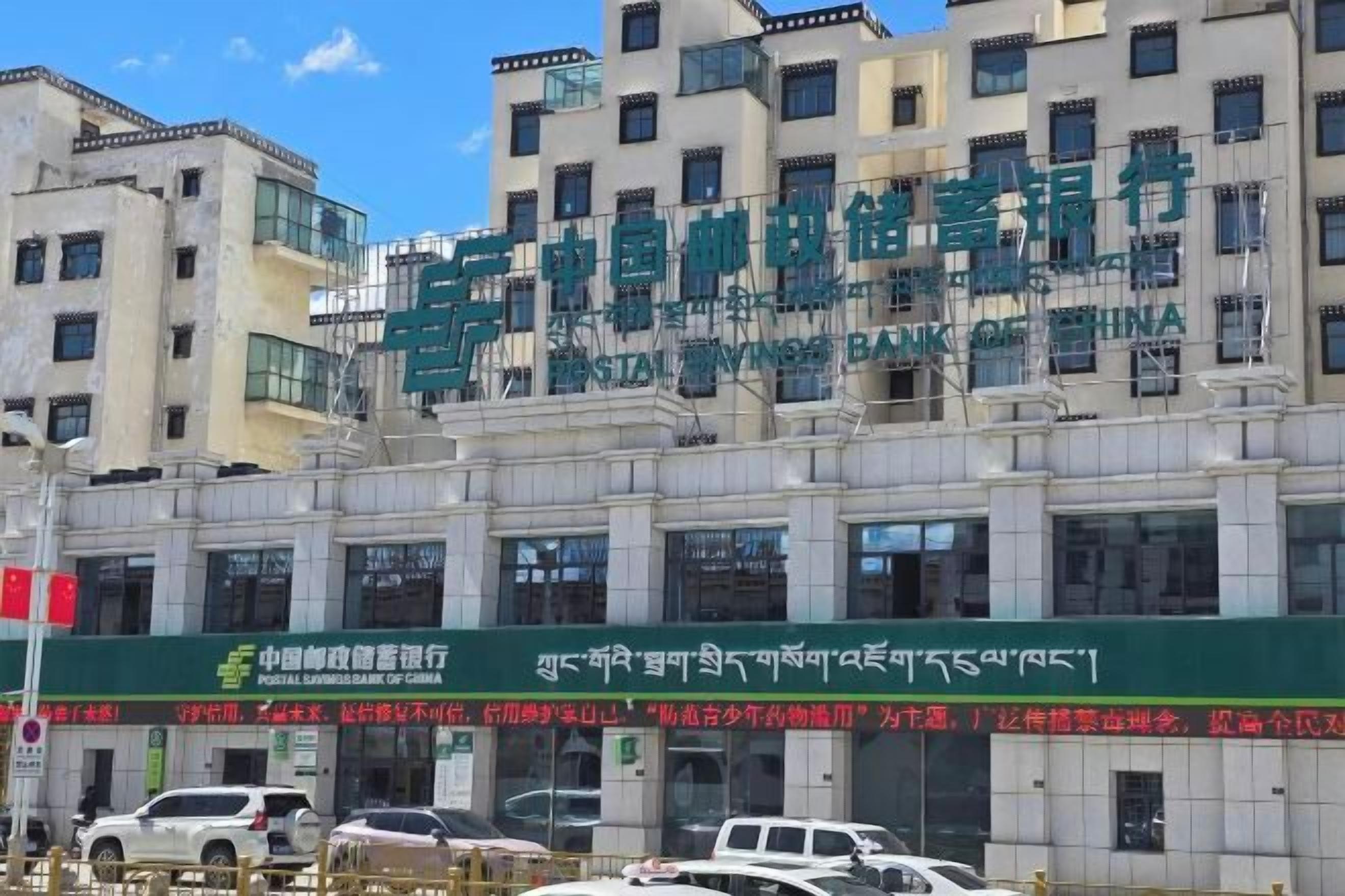 A multi-story building with signage indicating it is a postal service.