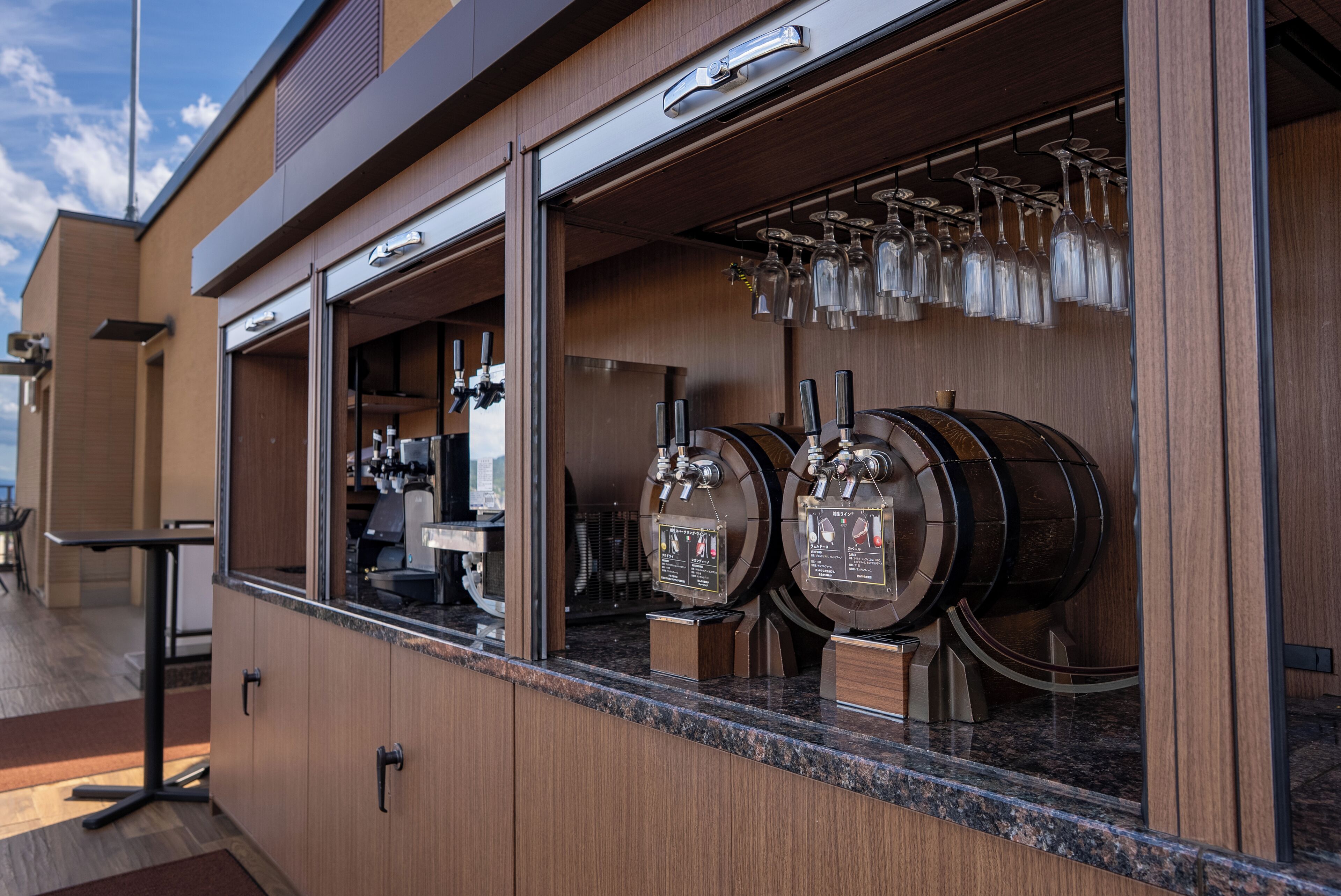 A bar area with a counter, wine glasses, and two beer taps.