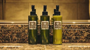 Trois flacons de produits pour le visage sont posés sur un comptoir en granit.