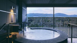 Un jacuzzi con vista a las montañas desde un balcón.