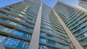 Un edificio de gran altura con varios pisos, ventanas amplias y un diseño arquitectónico moderno.