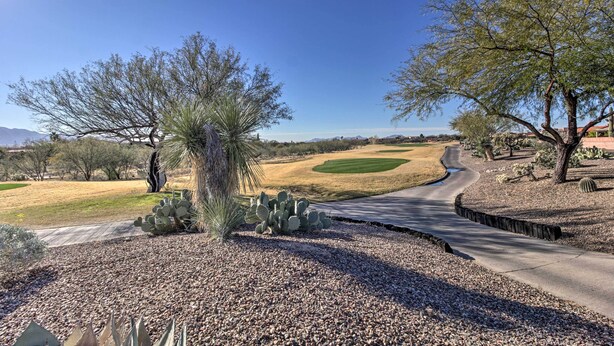 Un parcours de golf avec un chemin sinueux, des cactus et des arbres.