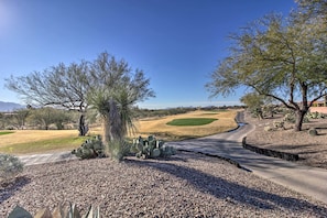 Ein Golfplatz mit einer gewundenen Straße, Kakteen und Bäumen.