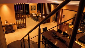 Een modern interieur met een trap naar een eethoek.
