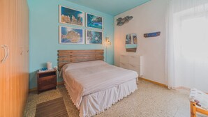 A bedroom with a bed, a nightstand, a dresser, and a ceiling fan. - BILOCALE NEL CENTRO DI PORTOFERRAIO (Portoferraio)