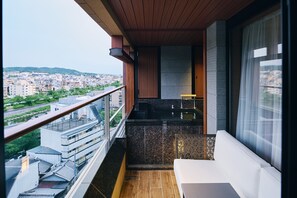 A balcony with a view of a cityscape, a seating area with a table, and a small kitchen area. - Sora Niwa Terrace Kyoto (Kyoto)