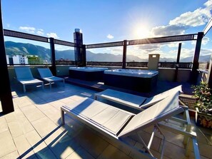 A rooftop terrace with lounge chairs, a hot tub, and a view of mountains. - Palermo Blu   MultiSuite   Appartamento Deluxe 1.2 (Palermo)