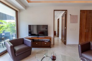 A living room with leather sofas, a glass coffee table, a flat-screen TV, and a wooden cabinet. - New listing! Pacifica 404 Casa Astro - Located in the heart of the Romantic Zone (Puerto Vallarta)