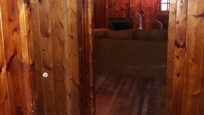 A wooden interior with a sofa and a lamp.