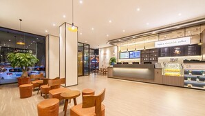 A modern coffee shop interior with wooden furniture and a digital menu display. - Hanting Hotel (Dalian)