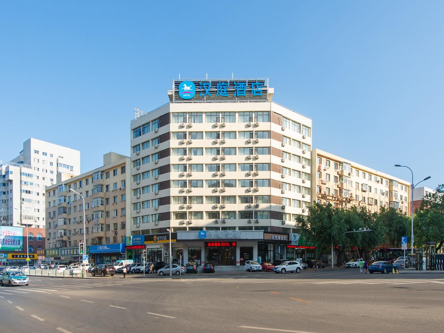 A hotel with multiple floors, air conditioning units, and a clear blue sky.