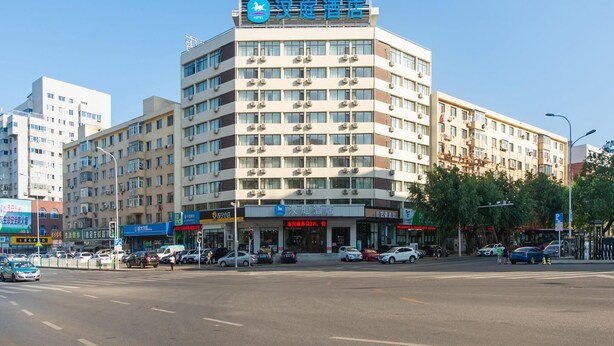 A hotel with multiple floors, air conditioning units, and a clear blue sky. - Hanting Hotel (Dalian)