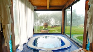 A hot tub with a view of a garden and trees.