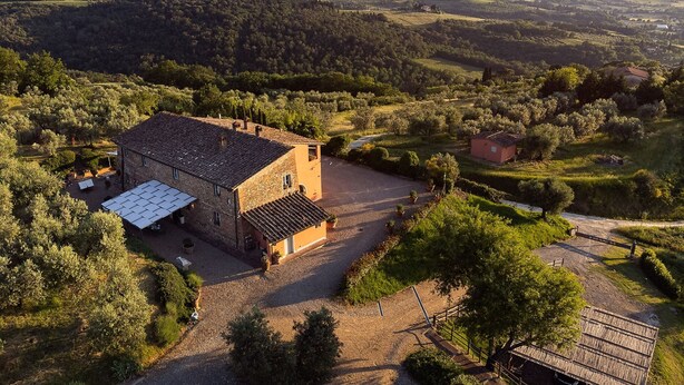 A stone building with a tiled roof, surrounded by a gravel driveway and potted plants. - Villa with pool in splendid panoramic location, just 20 minutes from Florence (Montelupo Fiorentino)
