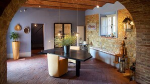 A cozy dining area with a rustic brick wall, a wooden table, and hanging lights. - Villa with pool in splendid panoramic location, just 20 minutes from Florence (Montelupo Fiorentino)