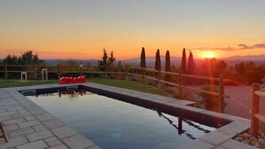A swimming pool with a wooden fence and a view of the sunset. - Villa with pool in splendid panoramic location, just 20 minutes from Florence (Montelupo Fiorentino)