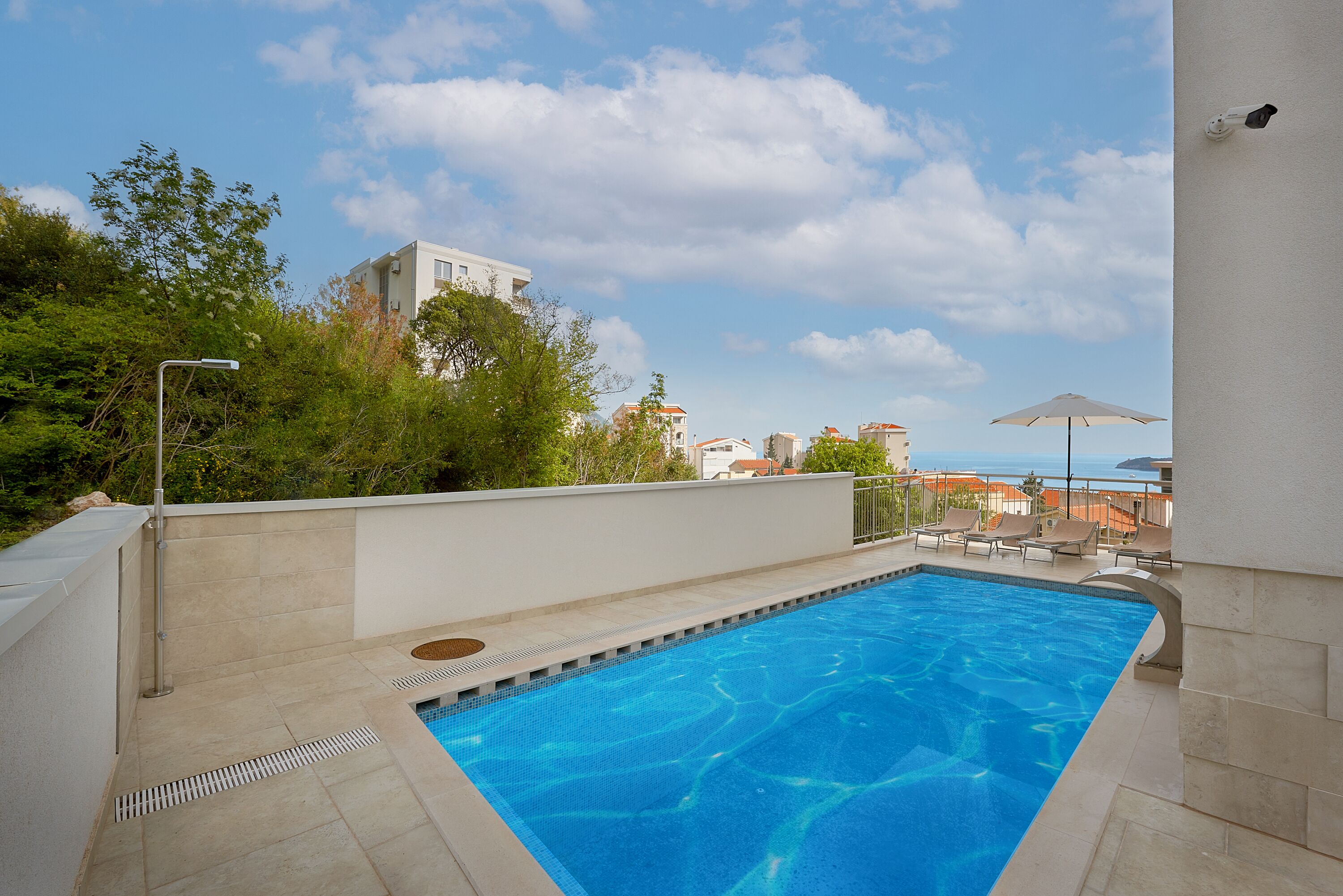 A swimming pool with a view of buildings and trees in the background.